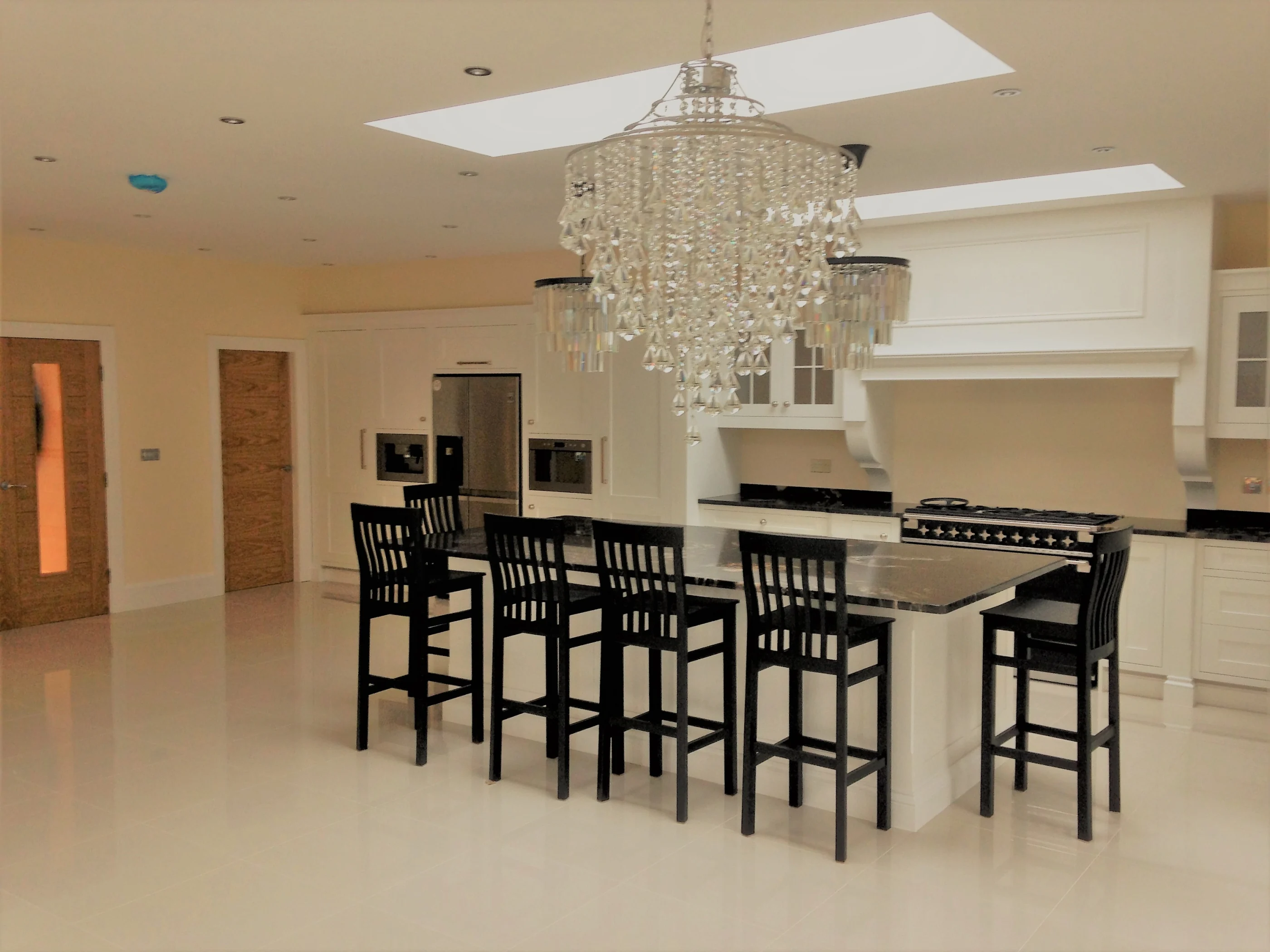 A white studio kitchen with a long island and dark range
