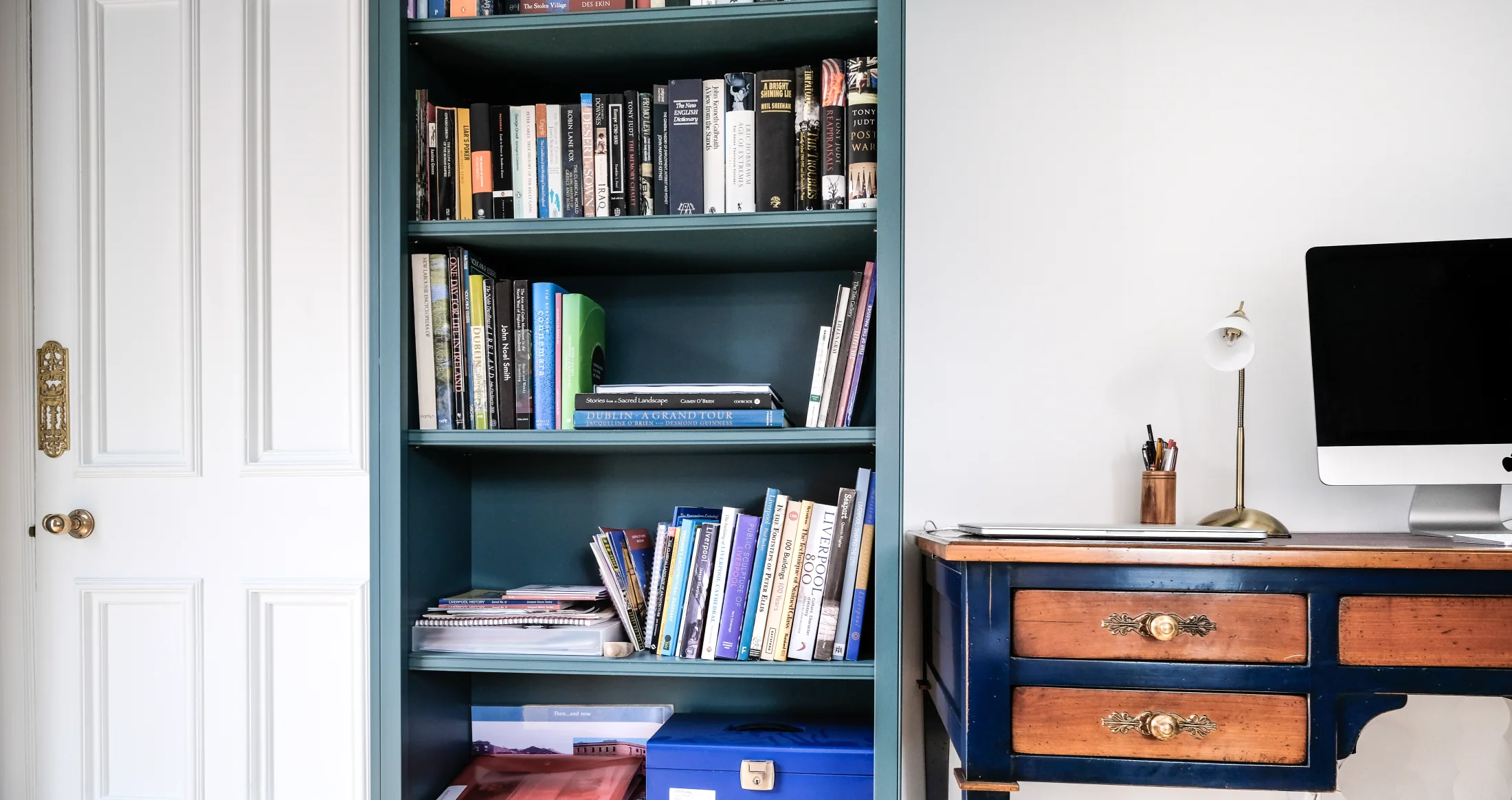 A close view of green fitted shelving meeting a freestanding desk
